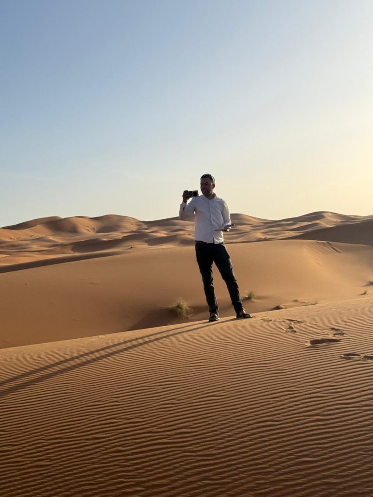 Homme photographiant les dunes du désert du Sahara à Merzouga, Maroc